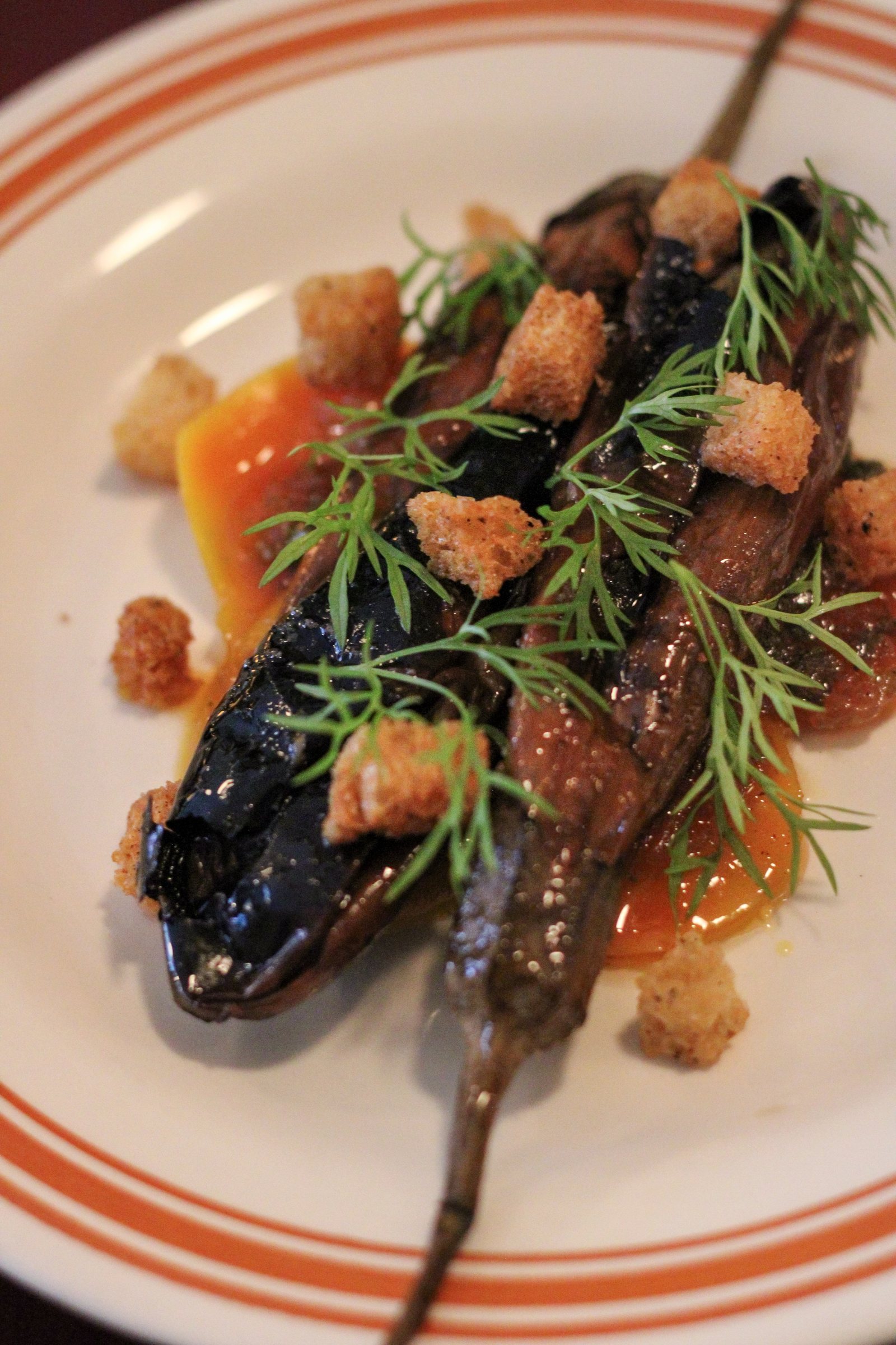 Close detail of the charred eggplant dish, dill and croutons