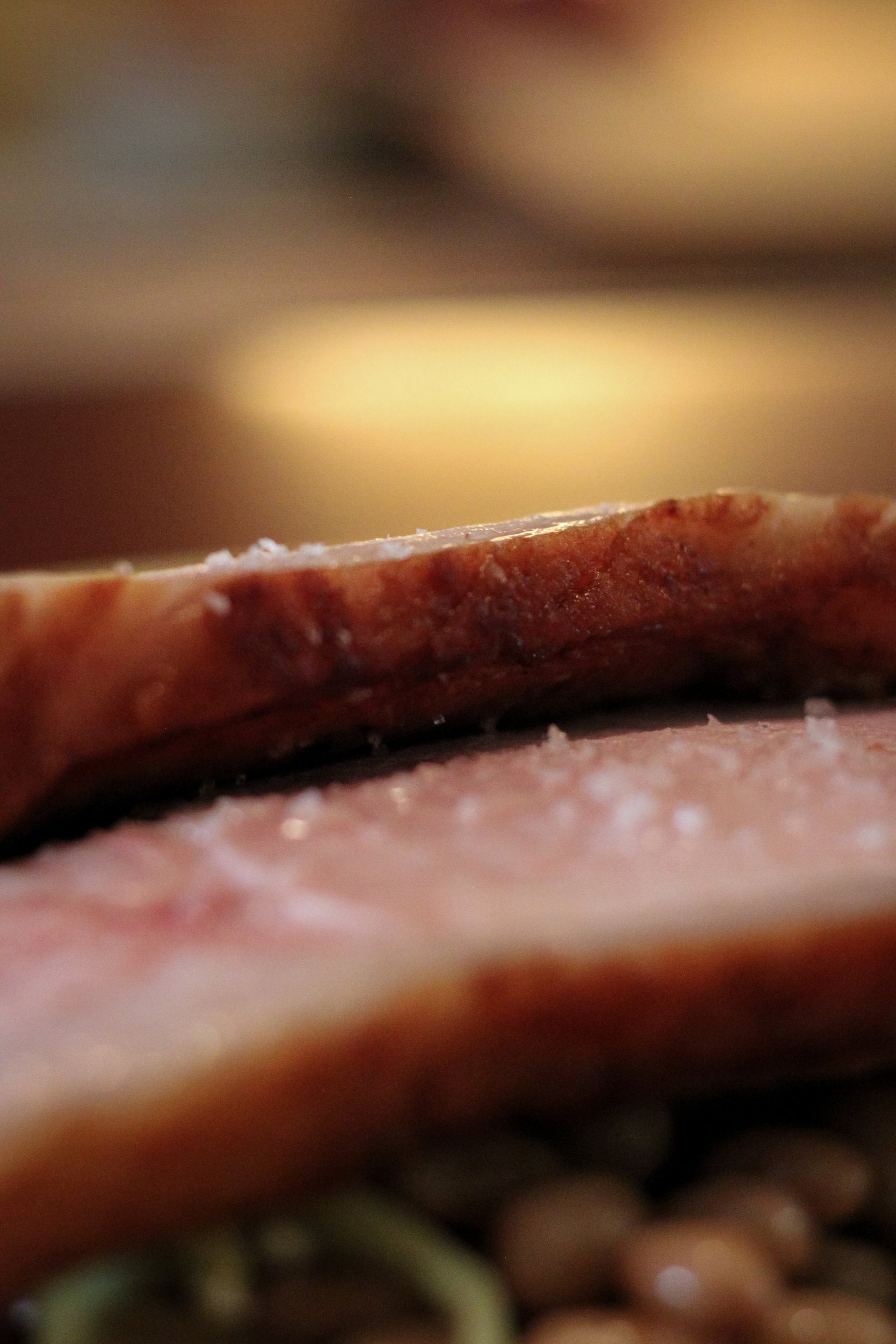 Macro detail of the pork slices, salt crystals catching the light